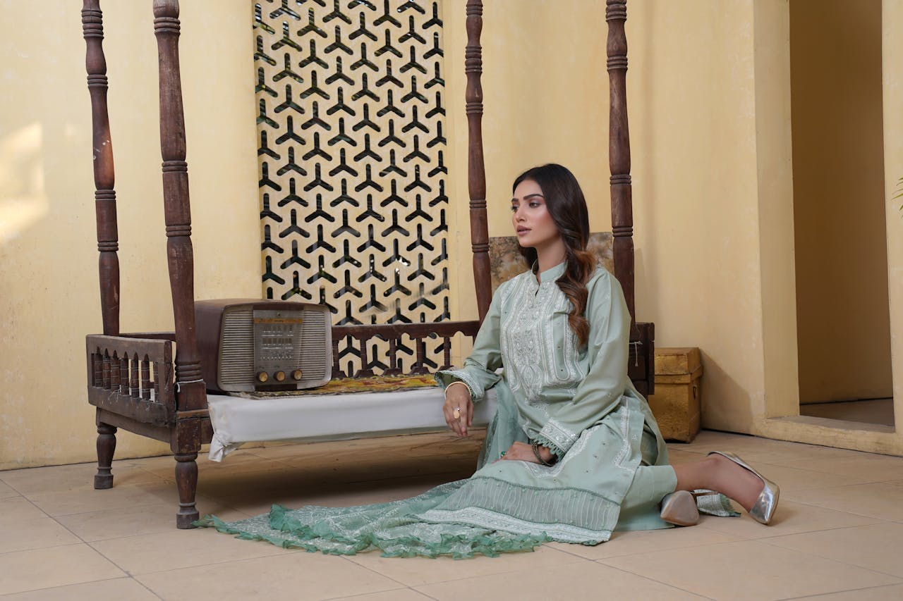 A woman in traditional attire posing indoors in Lahore, showcasing elegant style.